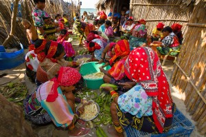 Kuna Indian women wearing native costumes with Mola embroderies cutting up bananas in their village on Corbisky Island, San Blas Islands (Kuna Yala), Caribbean Sea, Panama