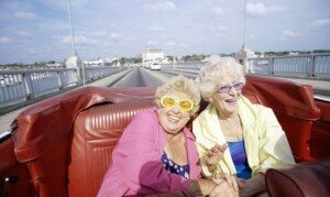Two senior women traveling together in a convertible car
